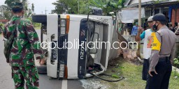 Hendak Mendahului Pendorong Motor, Truk Box Muatan Air Mineral Terguling