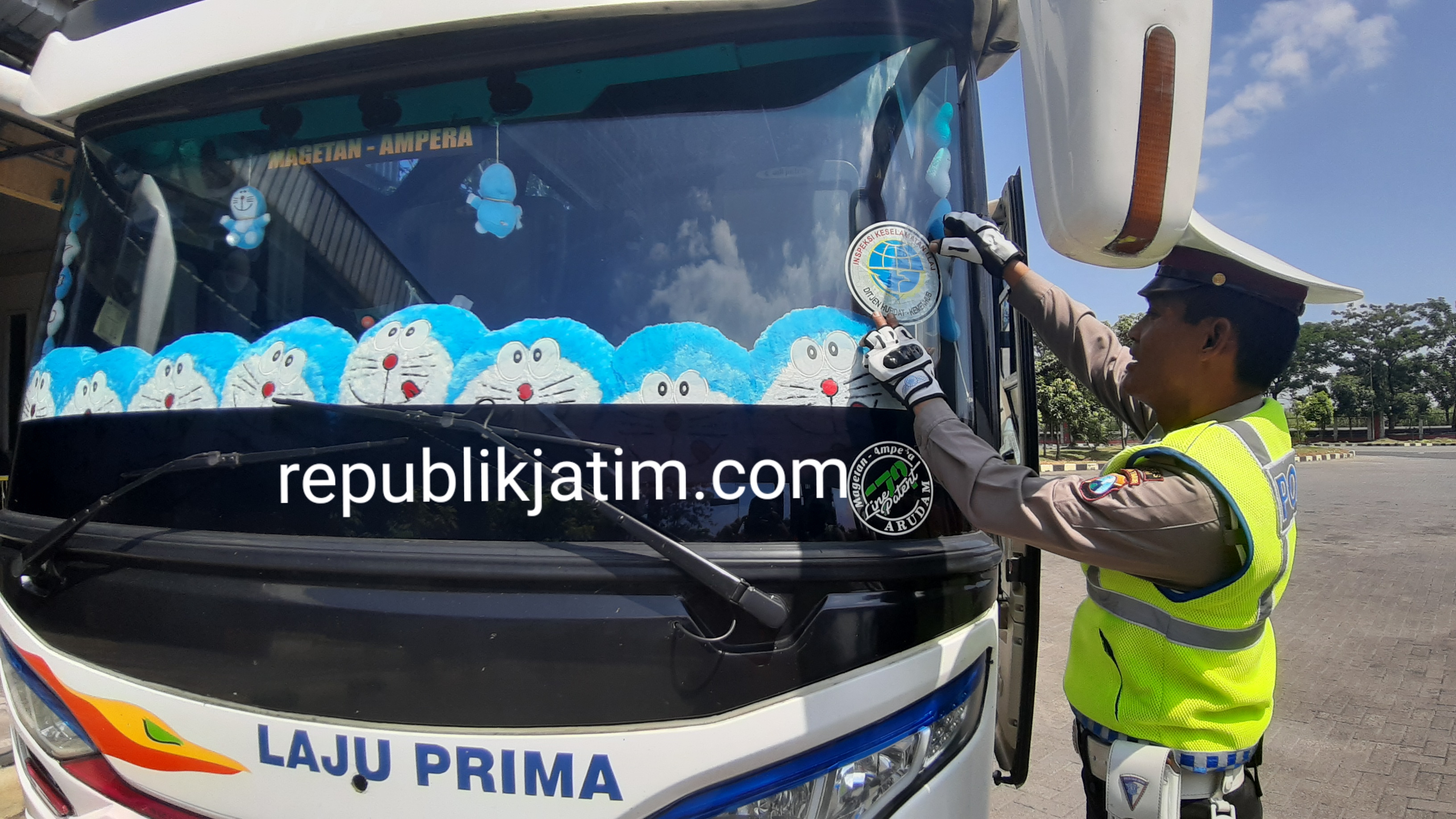 Petugas Satlantas Polres Ngawi tempelkan stiker di kaca bus yang lolos uji kelayakan kendaraan