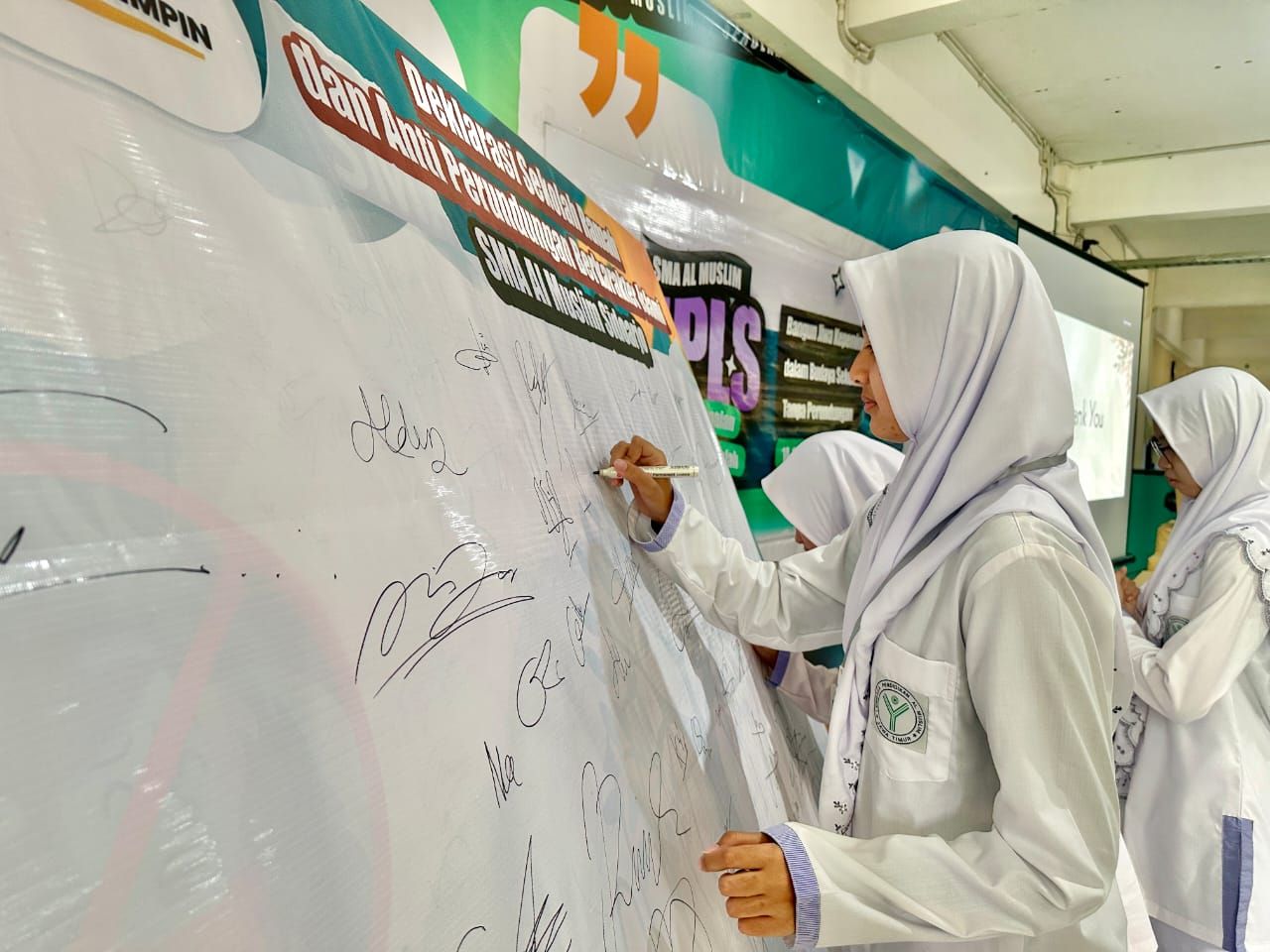 DEKLARASI - Para siswa dan siswi serta guru SMA Al Muslim deklarasi anti perundungan dengan menandatangani kain putih secara bergiliran saat penutupan MPLS Tahun 2025, Jumat (18/07/2025).