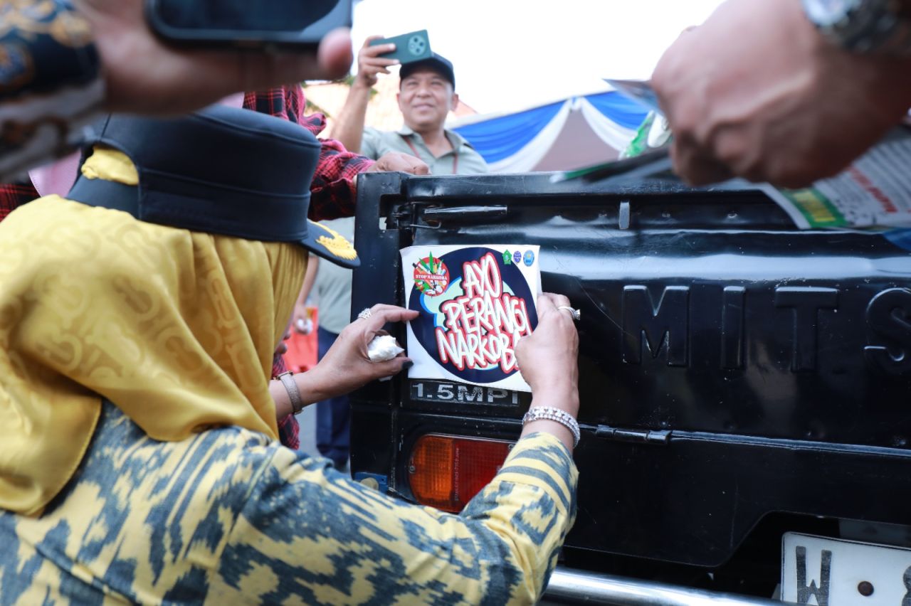 LAWAN NARKOBA - Wabup Sidoarjo Mimik Idayana bersama Kepala BNN Sidoarjo, Kombes Pol Gatot Soegeng Soesanto dan Kepala Dishub Budi Besuki menempel stiker saat apel khusus di Kantor Dishub Pemkab Sidoarjo, Selasa (14/10/2025).