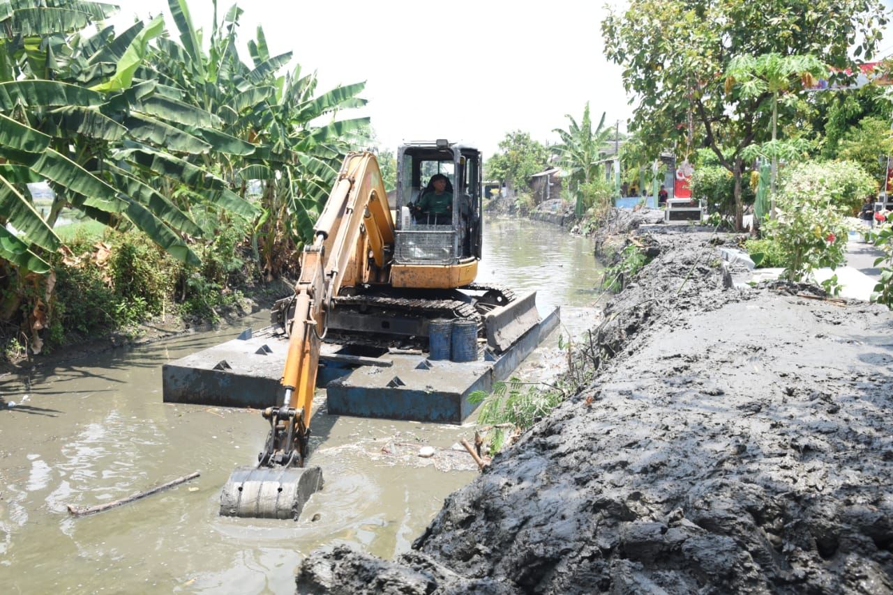 NORMALISASI - Dinas Pekerjaan Umum Bina Marga dan Sumber Daya Air (PUBM dan SDA) Pemkab Sidoarjo tengah melakukan normalisasi afvoer Kedungpeluk, Kecamatan Candi sepanjang 3 kilometer, Minggu (20/10/2025).