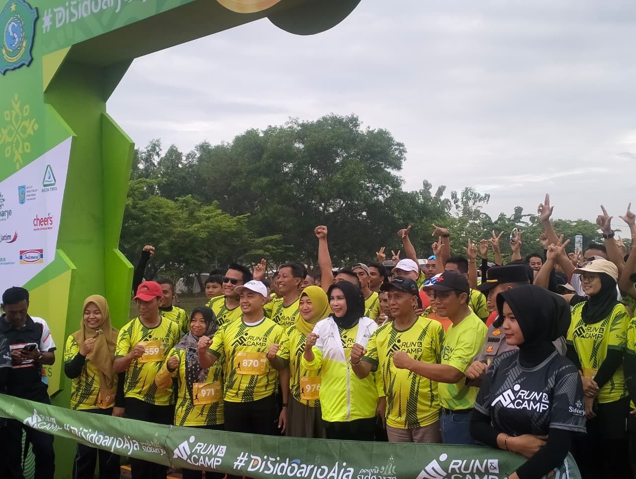 BERANGKATKAN - Wabup Sidoarjo Mimik Idayana didampingi Kepala Disporapar Sidoarjo Yudhi Iriyanto memberangkatkan peserta Run and Camp 2025 di Bumi Perkemahan Tanjekwagir, Kecamatan Krembung, Sidoarjo, Minggu (02/11/2025).