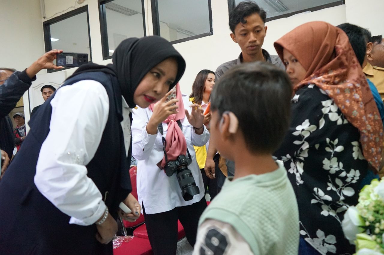 SERAHKAN - Wabup Sidoarjo Mimik Idayana didampingi Plt Kepala Dinas Sosial (Dinsos) Dedi Irwanto menyerahkan alat bantu dengar kepada puluhan penerima manfaat di Kantor Dinas Sosial (Dinsos) Pemkab Sidoarjo, Senin (24/11/2025).