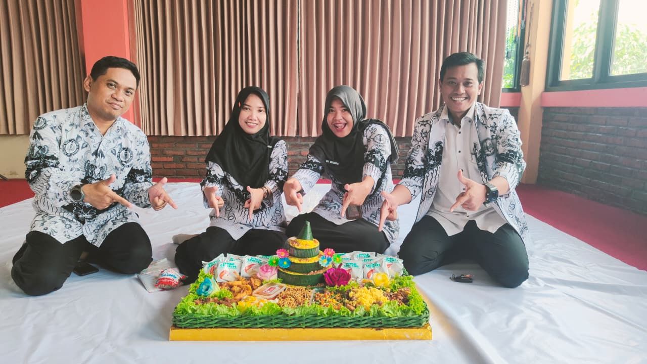 TUMPENG - Ketua Bidang Informasi dan Komunikasi (Infokom) PGRI Sidoarjo Emil Mukhtar Efendi bersama para pengurus lain menerima hadiah tumpeng dari Bupati Sidoarjo di Gedung Guru Delta Graha Dwija PGRI Sidoarjo, Selasa (25/11/2025).