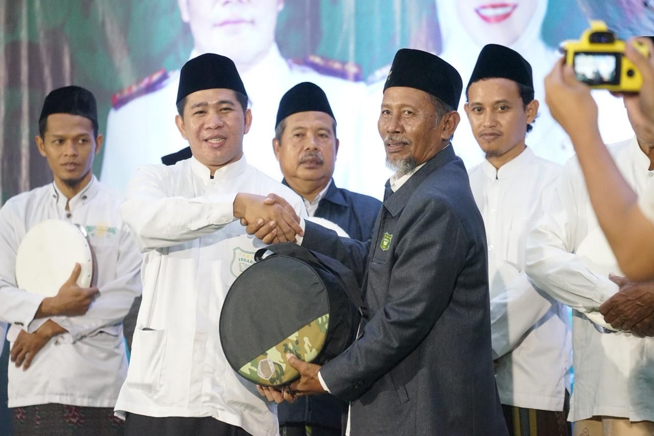 HADRAH - M Zakaria Dimas Pratama menyerahkan bantuan alat Hadrah bersamaan Lailatul Ishari dan Ngaji Budaya Seni Hadrah yang digelar di Kedungturi, Kecamatan Taman, Sidoarjo kolaborasi yang diinisiasi Pemkab, PC ISHARI dan PC IKAPMII, Sabtu (29/11/2025).