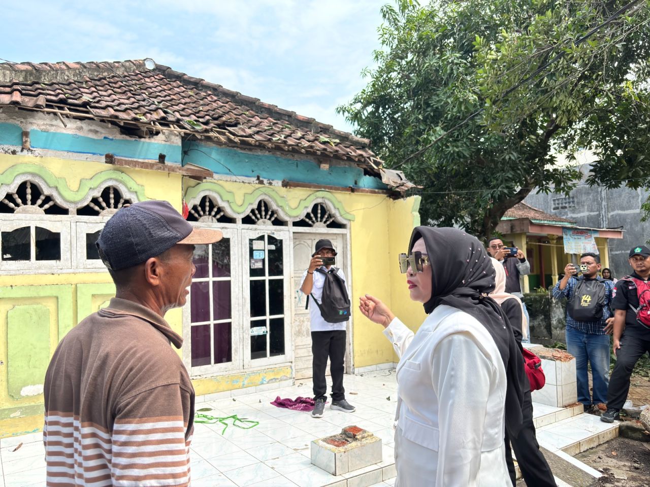 CEK - Wakil Bupati (Wabup) Sidoarjo Mimik Idayana meninjau rumah warga Desa Kedungsugo, Kecamatan Prambon, yang rusak diterjang angin kencang (puting beliung) sekaligus memastikan penanganannya, Kamis (11/12/2025).