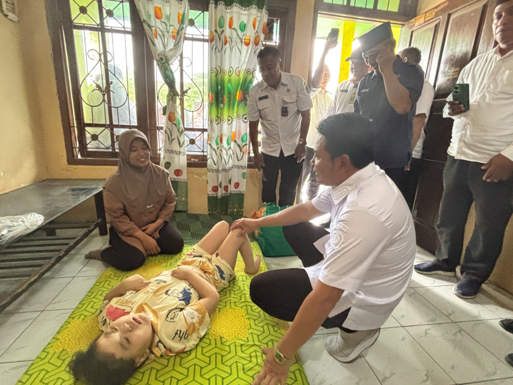 KURSI RODA - Bupati Sidoarjo Subandi datang ke rumah Naysha Aulia Farzana (8) yang terlahir dengan kondisi Down syndrome menyerahkan bantuan kursi roda di Desa Watutulis Kecamatan Prambon, Sidoarjo, Rabu (24/12/2025).