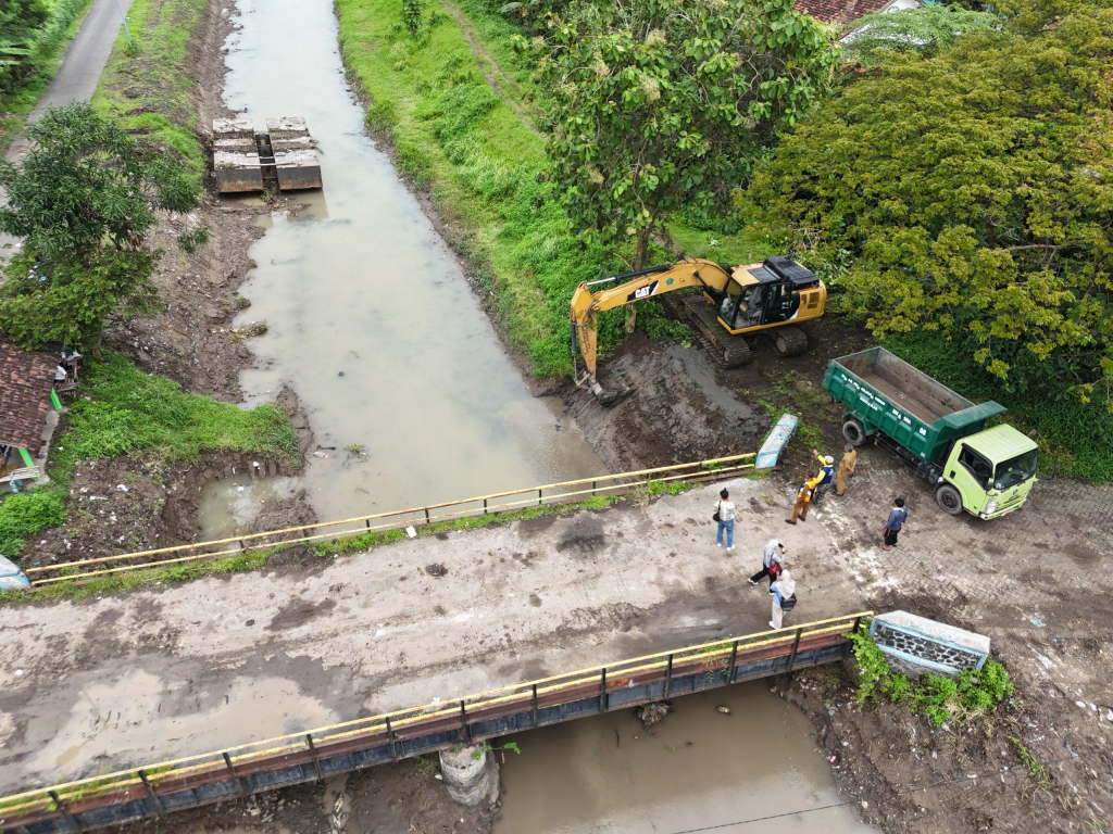NORMALISASI - Dinas Pekerjaan Umum Bina Marga dan Sumber Daya Air (PUBM dan SDA) normalisasi sungai di berbagai titik sebagai mitigasi banjir dan pembersihan sedimen seperti di Sungai Mojoruntut, Kecamatan Krembung, Senin (09/02/2026).