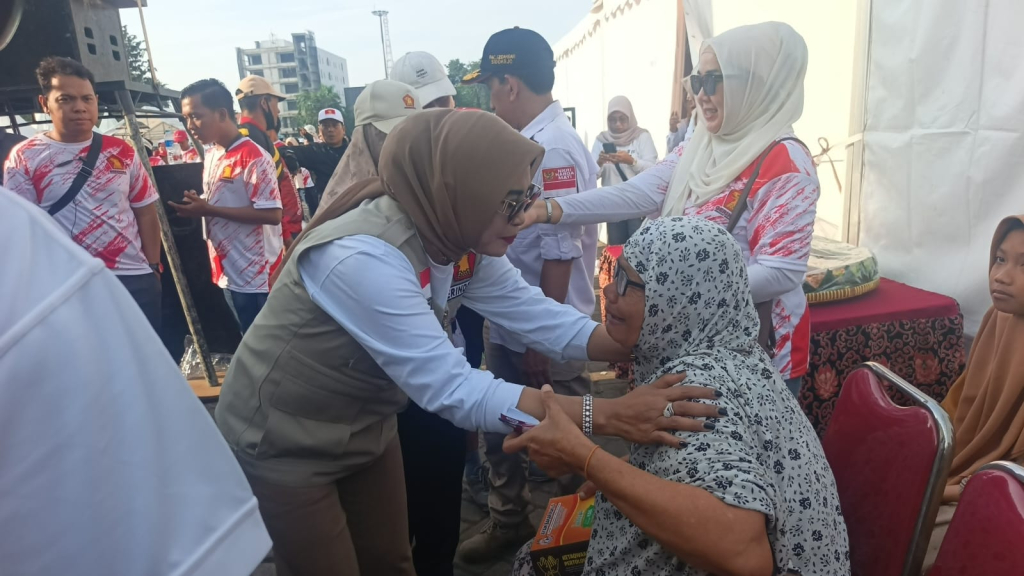 PELUK - Mbah Romlah (65) warga Buduran, Sidoarjo menangis dan terharu saat l dipeluk Wakil Bupati (Wabup) Sidoarjo Mimik Idayana di acara HUT Partai Gerindra di Lapangan Timur GOR Sidoarjo, Minggu (15/02/2026).