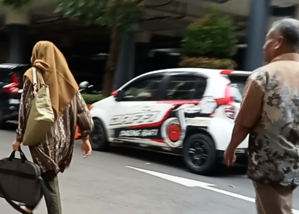 MENGHINDAR - Kades Sukorejo Suwandi dan Sekdesnya Putri Ambeg Isnaini menghindari media usai diperiksa tim penyidik Subdit II Harda Bangtah Ditkrimum Polda Jawa Timur (Jatim) di Polda Jatim, Kamis (02/04/2026).