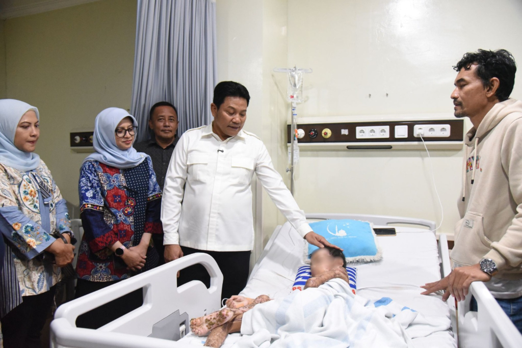 JENGUK - Bupati Sidoarjo Subandi menjenguk Muhammad Izzan Dwi Arifianto yang setahun lalu kehilangan ibu dan kakaknya saat kebakaran hebat kini harus berjuang di ruang isolasi combustio RSUD RT Notopuro untuk kesembuhan luka bakar, Selasa (16/06/2026).