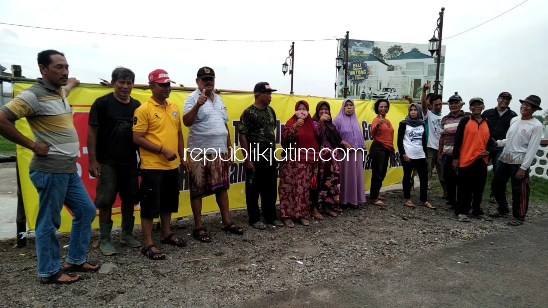 TUTUP JALAN - Puluhan petani gogol Desa Gelang, Kecamatan Tulangan, Sidoarjo menutup akses jalan menuju perumahan Modern Land menggunakan spanduk raksasak (besar), Rabu (01/01/2020).
