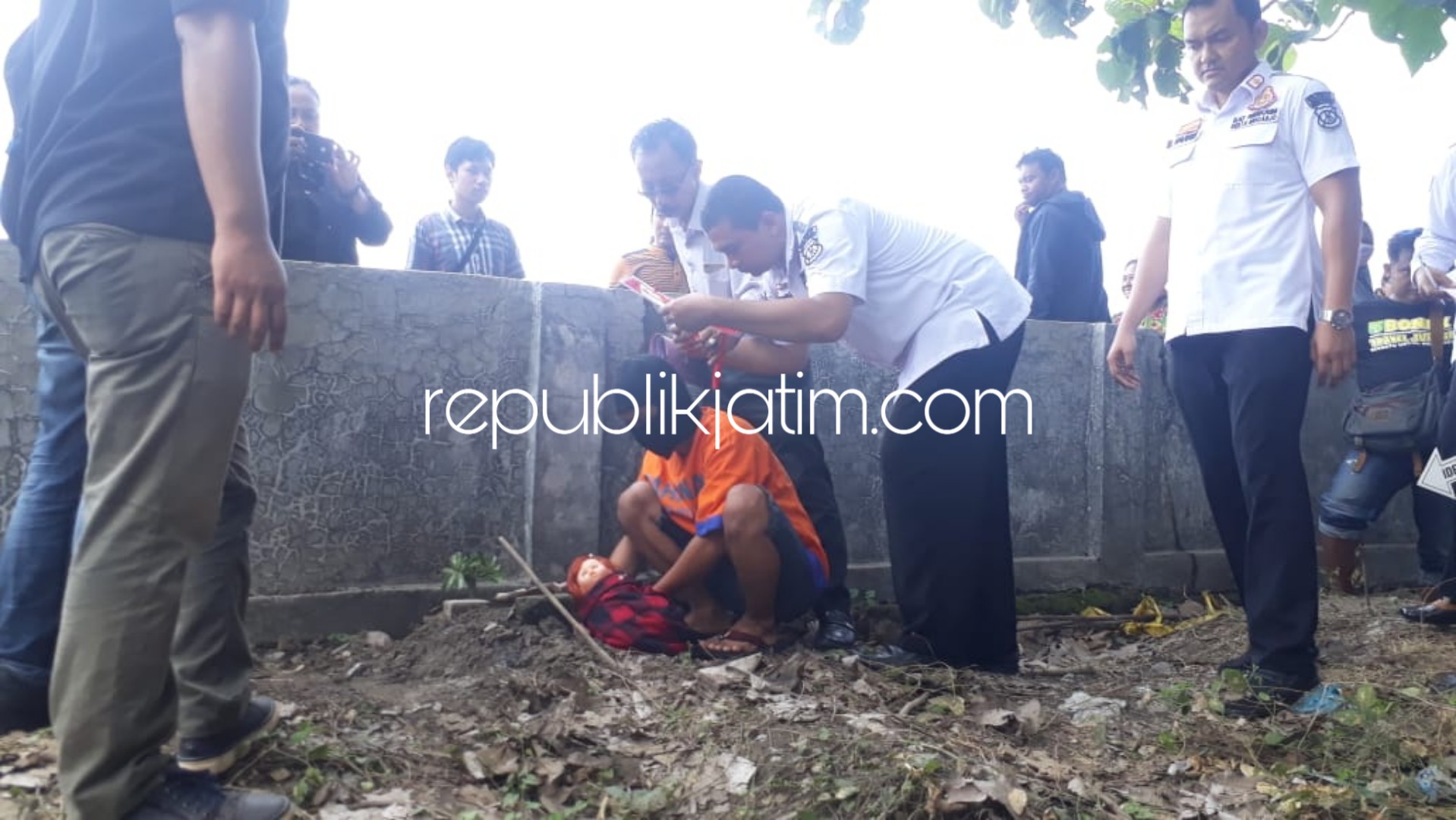 ADEGAN - Tersangka RM (18) memeragakan 26 adegan penguburan bayi hasil hubungan gelapnya di TPU Dusun Wagir, Desa Kwangsan, Kecamatan Sedati, Sidoarjo bersama rekannya AG, Rabu (09/01/2019).