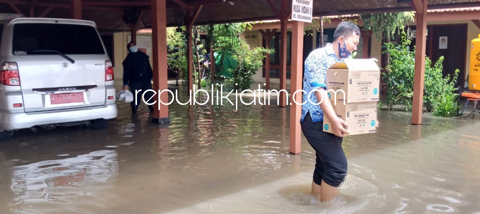 BANJIR - Kasi Pemeritahan Desa Pesawahan, Setiawan menyelamatkan sejumlah dokumen dan arsip dari Balai Desa ke tempat yang lebih aman, Senin (18/01/2021).