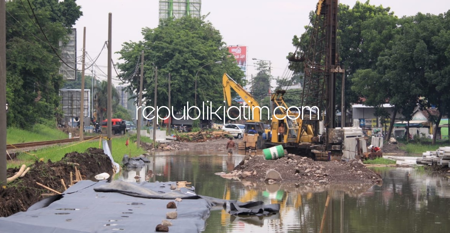 TERENDAM - Sejumlah alat berat yang digunakan mengerjakan proyek Frontage Road (FR) di bawah patung pesawat kawasan timur Aloha, Kecamatan Gedangan, Sidoarjo tergenang banjir hingga mesinnya sempat mogok, Selasa (19/01/2021). 