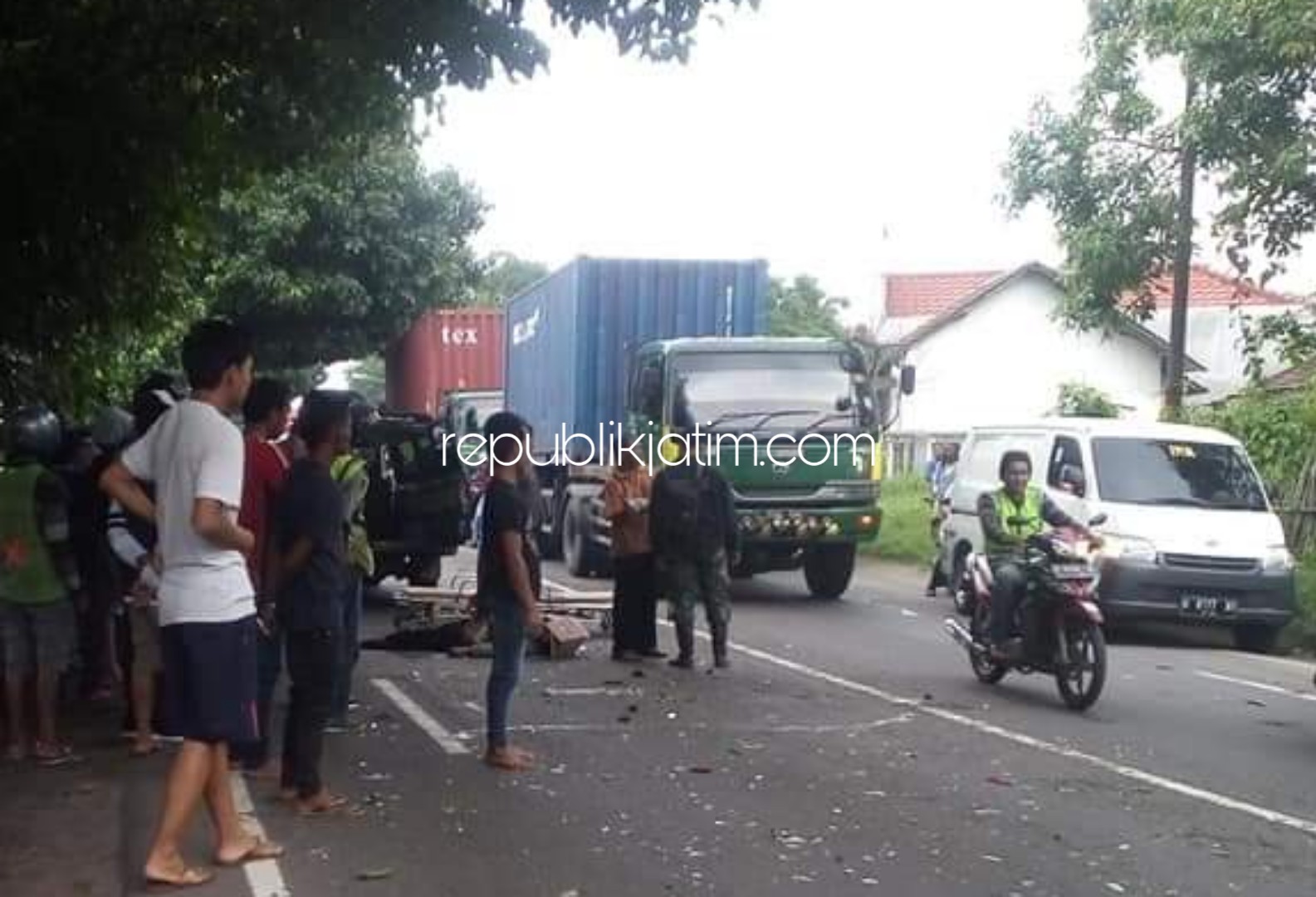 TABRAKAN - Sejumlah pengguna jalan mengevakuasi jenazah korban kecelakaan yang melibatkan motor dan bus di JL Raya Mojokerto - Surabaya, Desa Kramattemenggungan, Kecamatan Tarik, Sidoarjo, Senin (20/01/2020). 