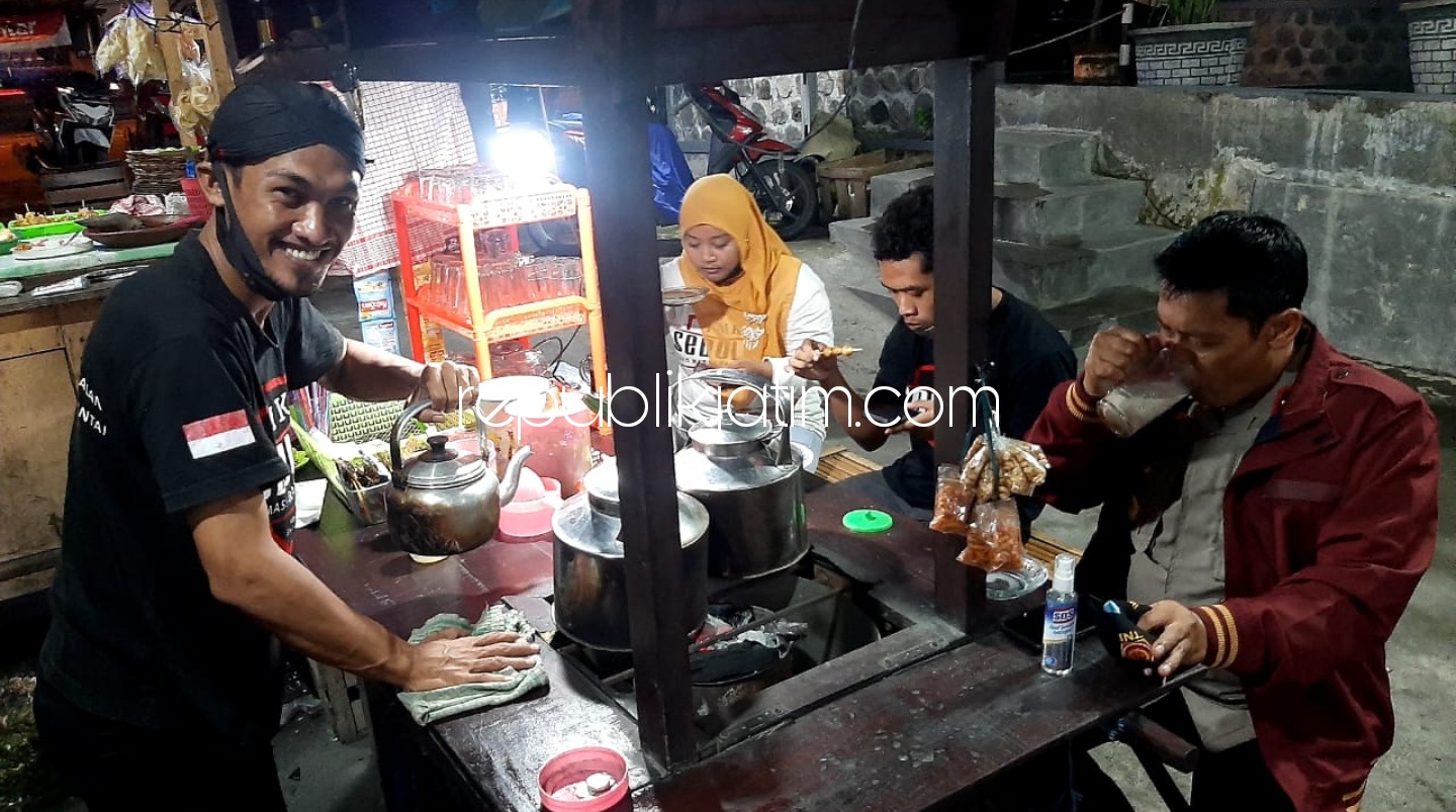 ANGKRINGAN - Salah satu pelanggan Kapolsek Krian, Kompol Mukhlason saat menikmati menu nasi bakar dan jahe susu di Angkringan Warso JL Raya Kemangsen, Kecamatan Balongbendo, Sidoarjo, Jumat (22/01/2021) malam.