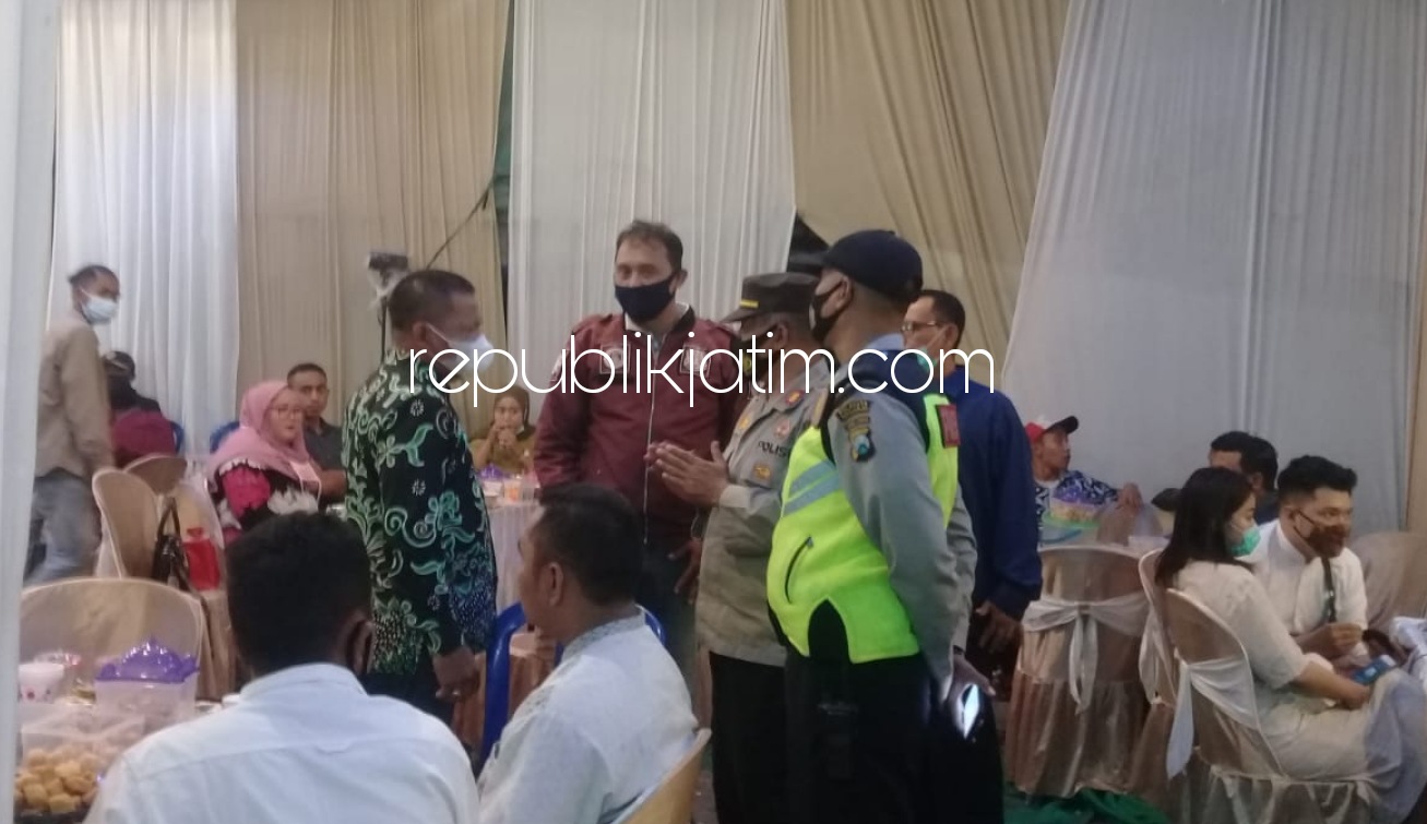 BUBARKAN - Sejumlah petugas gabungan dari Kecamatn Krian menghentikan hajatan salah satu warga di Desa Jerukgamping, Kecamatan Krian, Sidoarjo, Sabtu (23/01/2021).