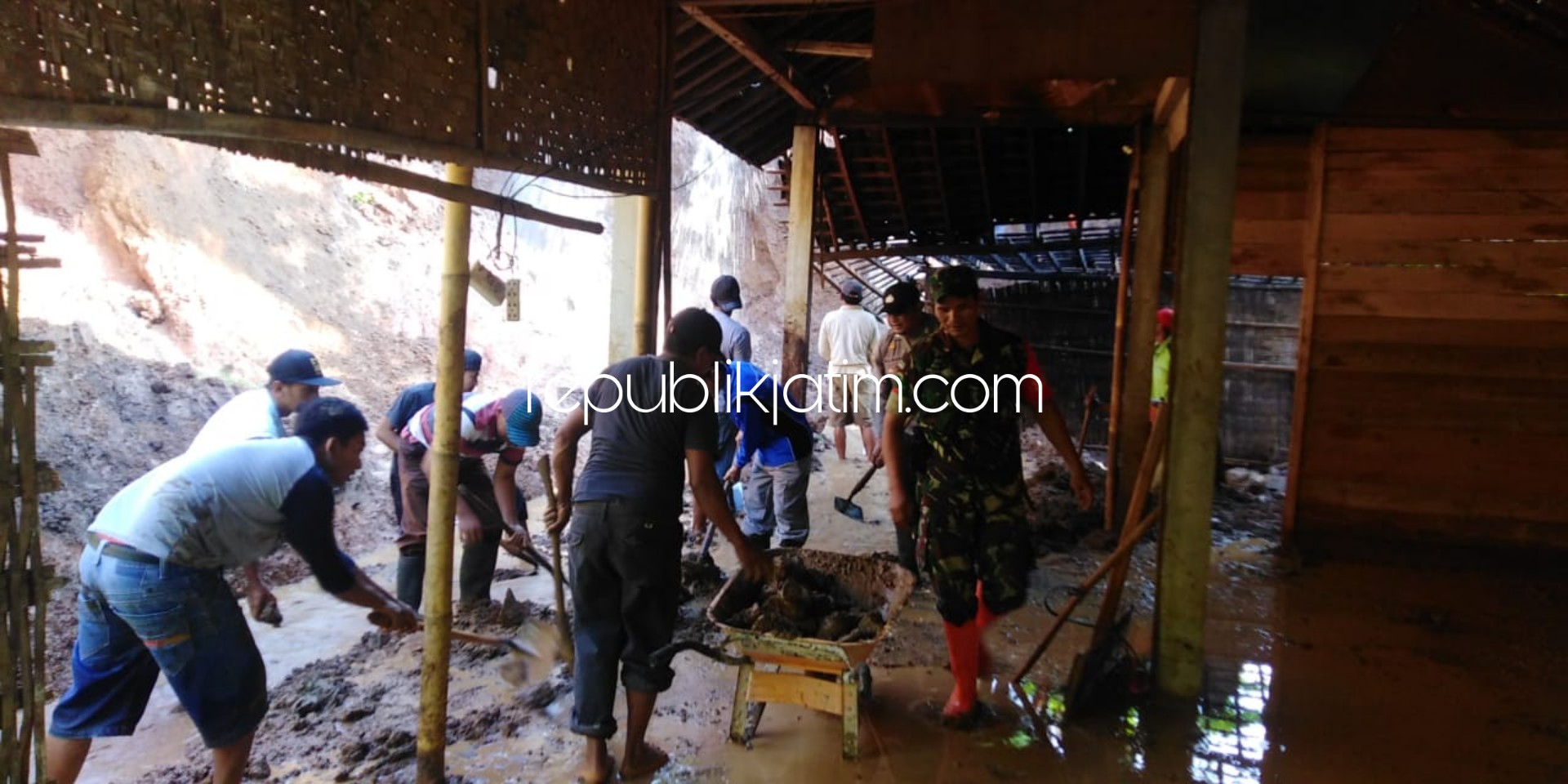 LONGSOR - Petugas Polsek, Kodim, Banser dan warga Pulung bekerka bakti membersihkan lumpur longsor yang menerjang rumah milik Ny Ami (60) warga Dusun Kerep, Desa Wagirkidul, Kecamatan Pulung, Ponorogo, Minggu (26/01/2020).