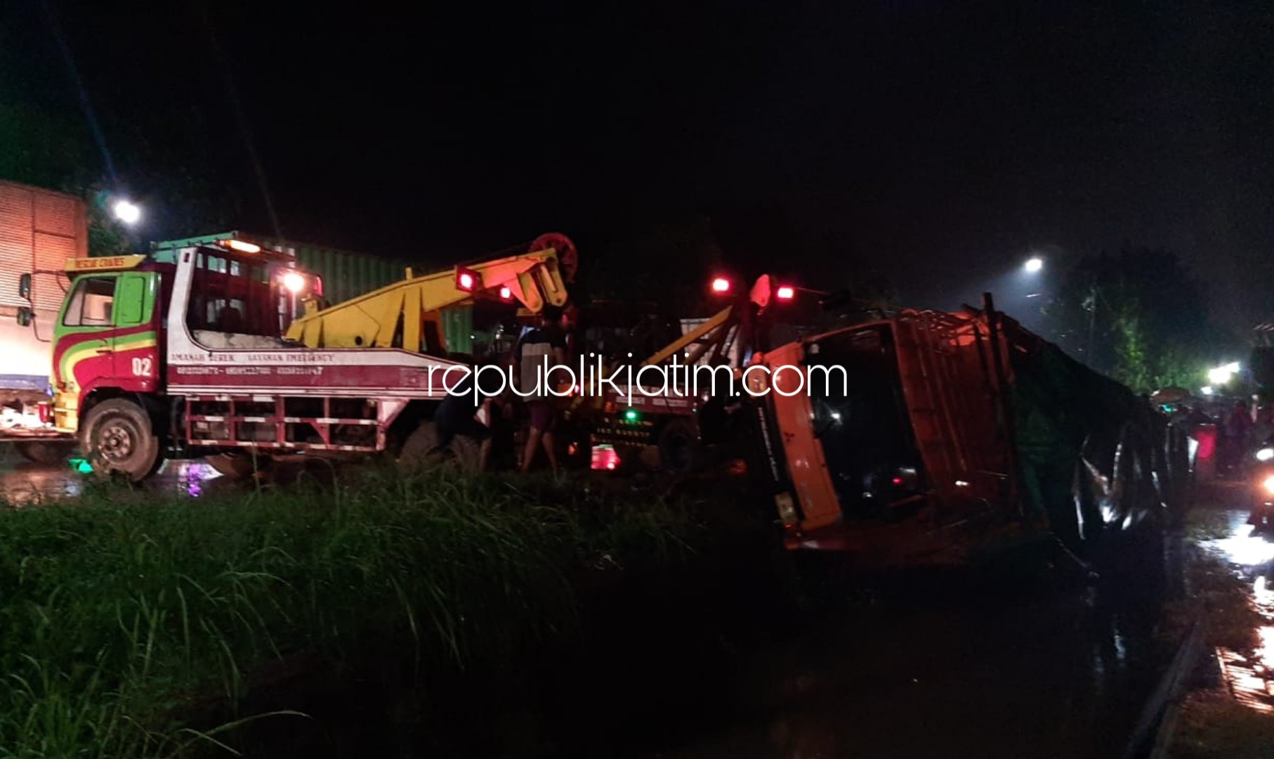 EVAKUASI - Truk Fuso bermuatan bahan kimia cair dievakuasi mobil derek dan petugas Polsek Balongbendo dari sungai di JL Raya Surabaya - Mojokerto, Dusun Tado, Desa Singkalan, Kecamatan Balongbendo, Sidoarjo, Jumat (31/01/2020). 