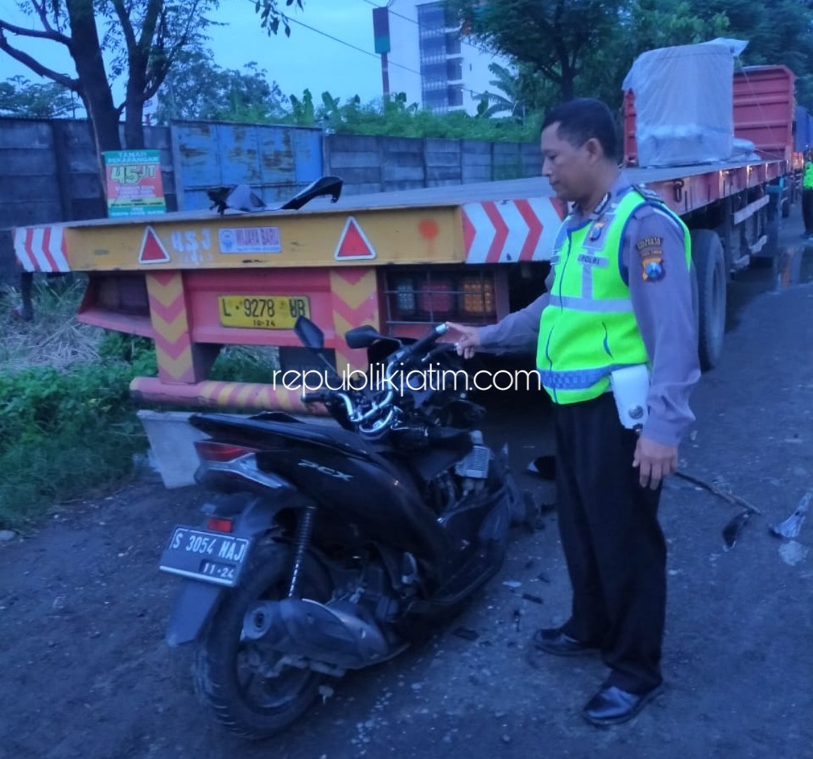 EVAKUASI - Petugas Unit Lantas Polsek Balongbendo menggelar olah TKP di jalur by pass Balongbendo seusai motor tabrak truk kontainer parkir, Minggu (09/02/2020).