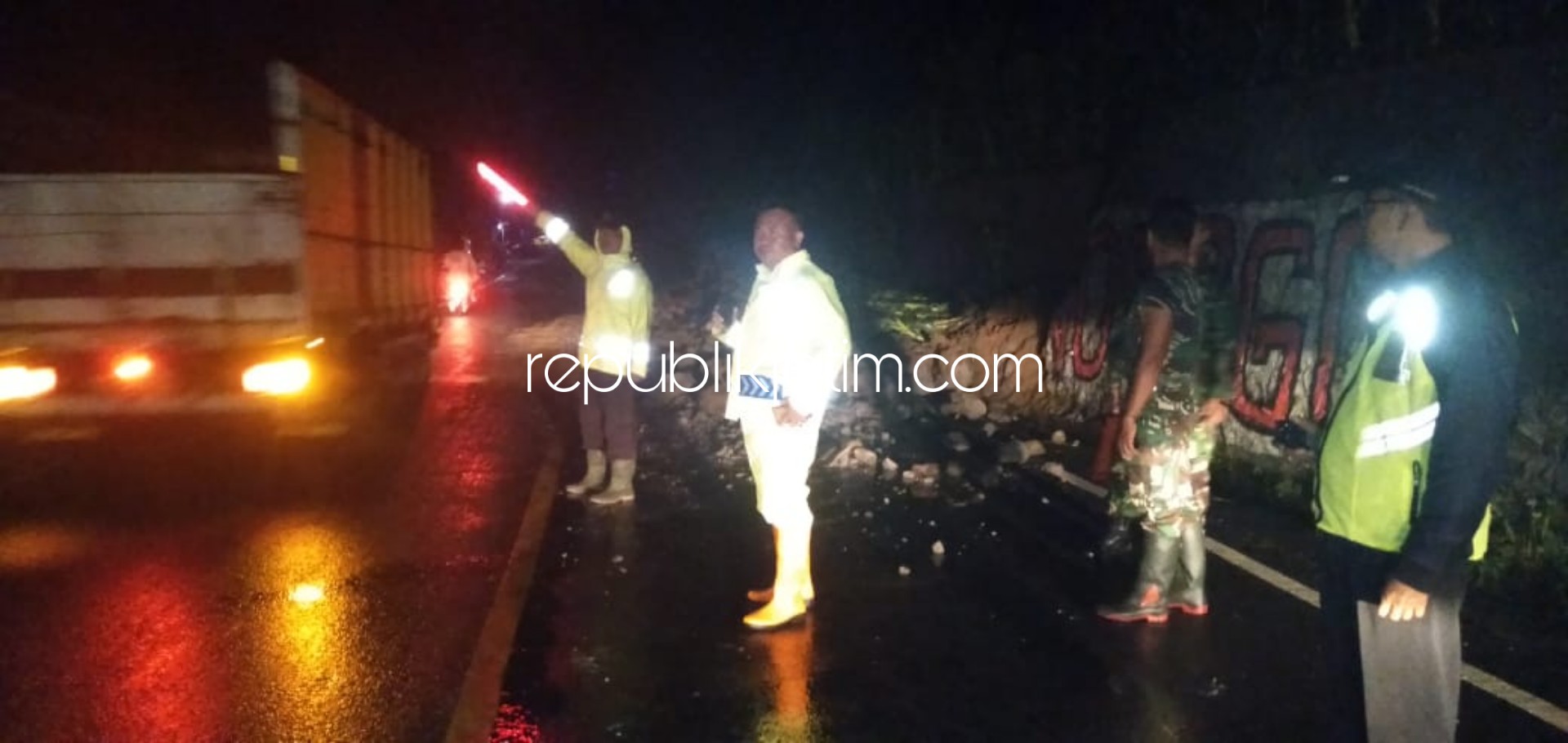 MACET - Polisi bersama anggota Koramil, warga dan tim BPBD mengevakuasi material longsor agar jalur Ponorogo-Trenggalek yang tertutup longsor segera terbuka kembali, Minggu (16/02/2020) malam.