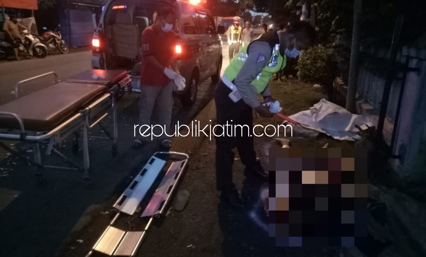 EVAKUASI - Petugas Unit Lantas Polsek Krian mengevakuasi korban kecelakaan di JL Raya Desa Sedenganmijen, Kecamatan Krian, Sidoarjo, Minggu (21/02/2021).