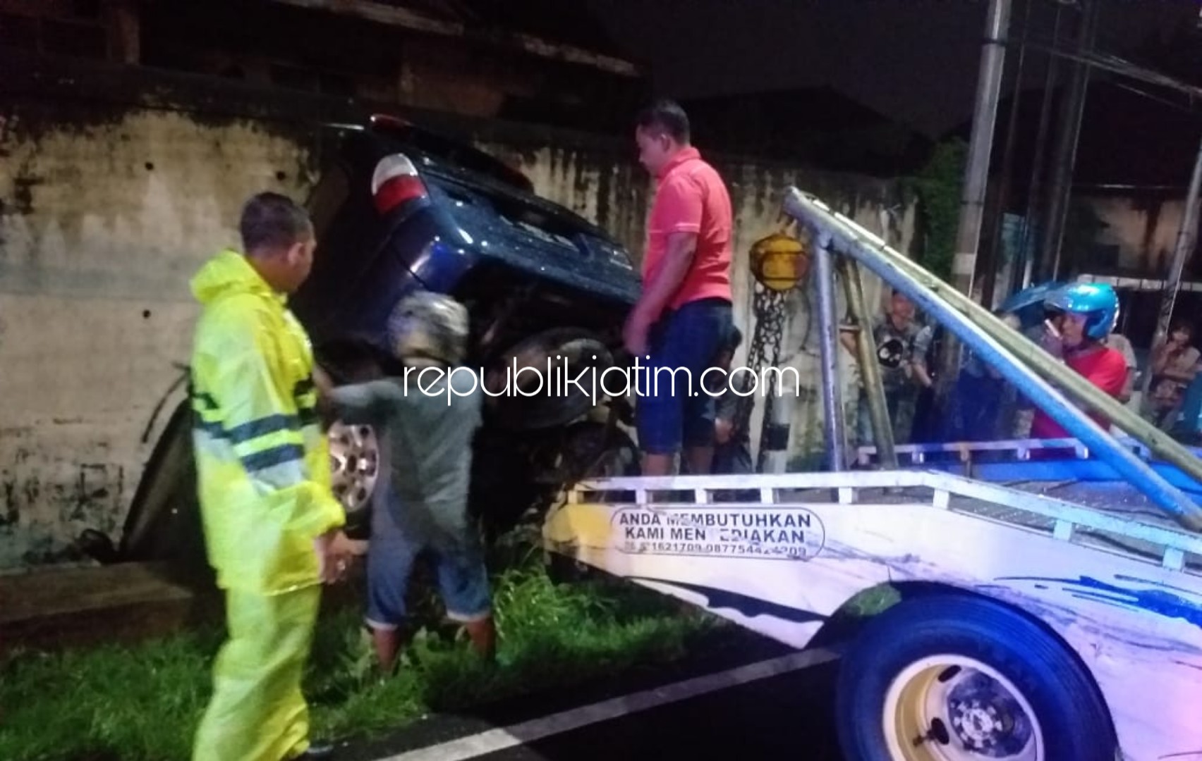 EVAKUASI - Petugas mengevakuasi mobil Panther warna biru yang tersangkut pembatas jalan di JL Raya Gempol-Porong Kelurahan/Kecamatan Porong, Sidoarjo, Minggu (23/02/2020) malam. 