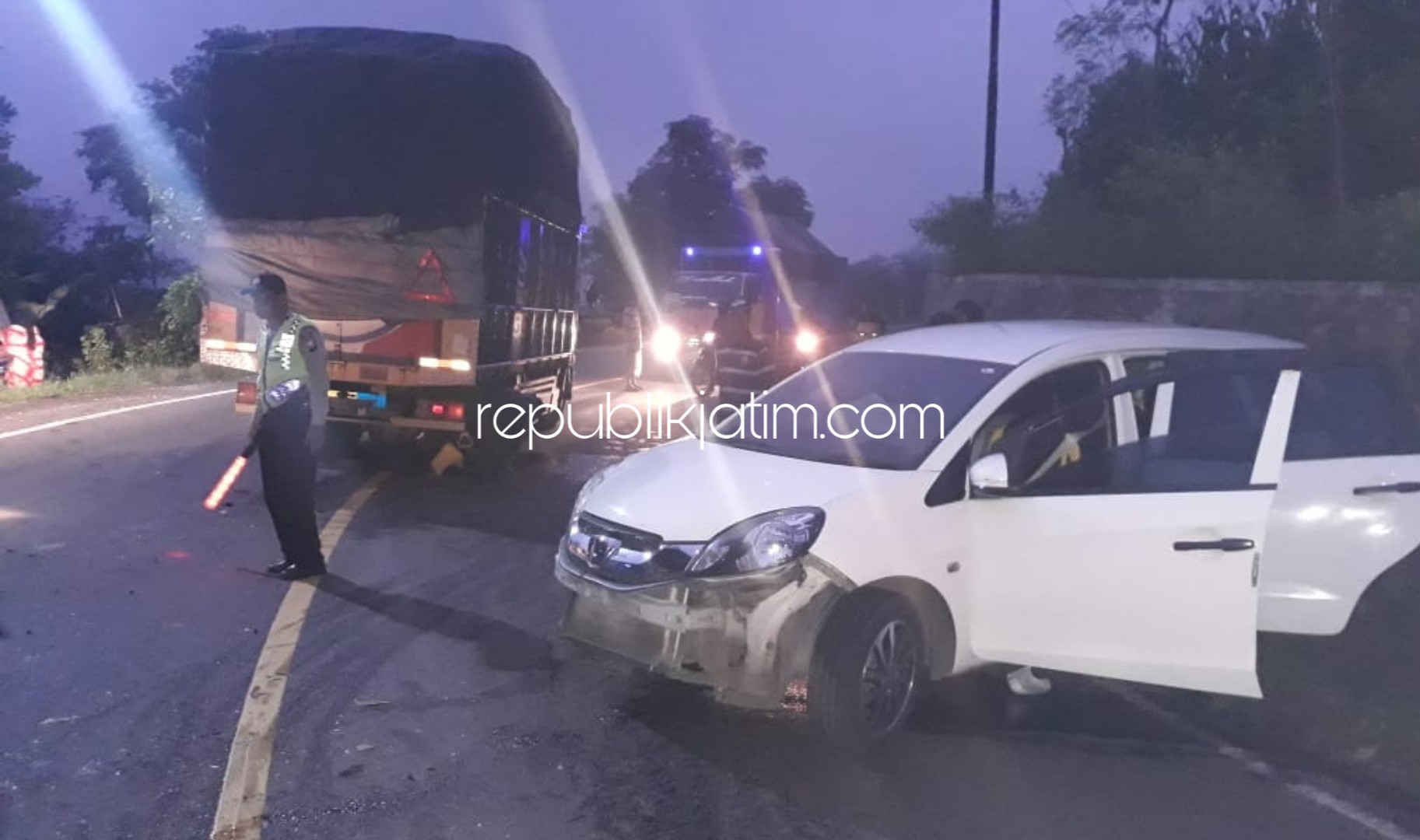 EVAKUASI - Petugas Polsek Sawoo mengevakuasi bangkai truk dan mobil Honda Mobilio usai tabrakan di JL Raya Ponorogo - Trenggalek Dusun Ngemplak Desa/Kecamatan Sawoo, Ponorogo, Senin (24/02/2020).