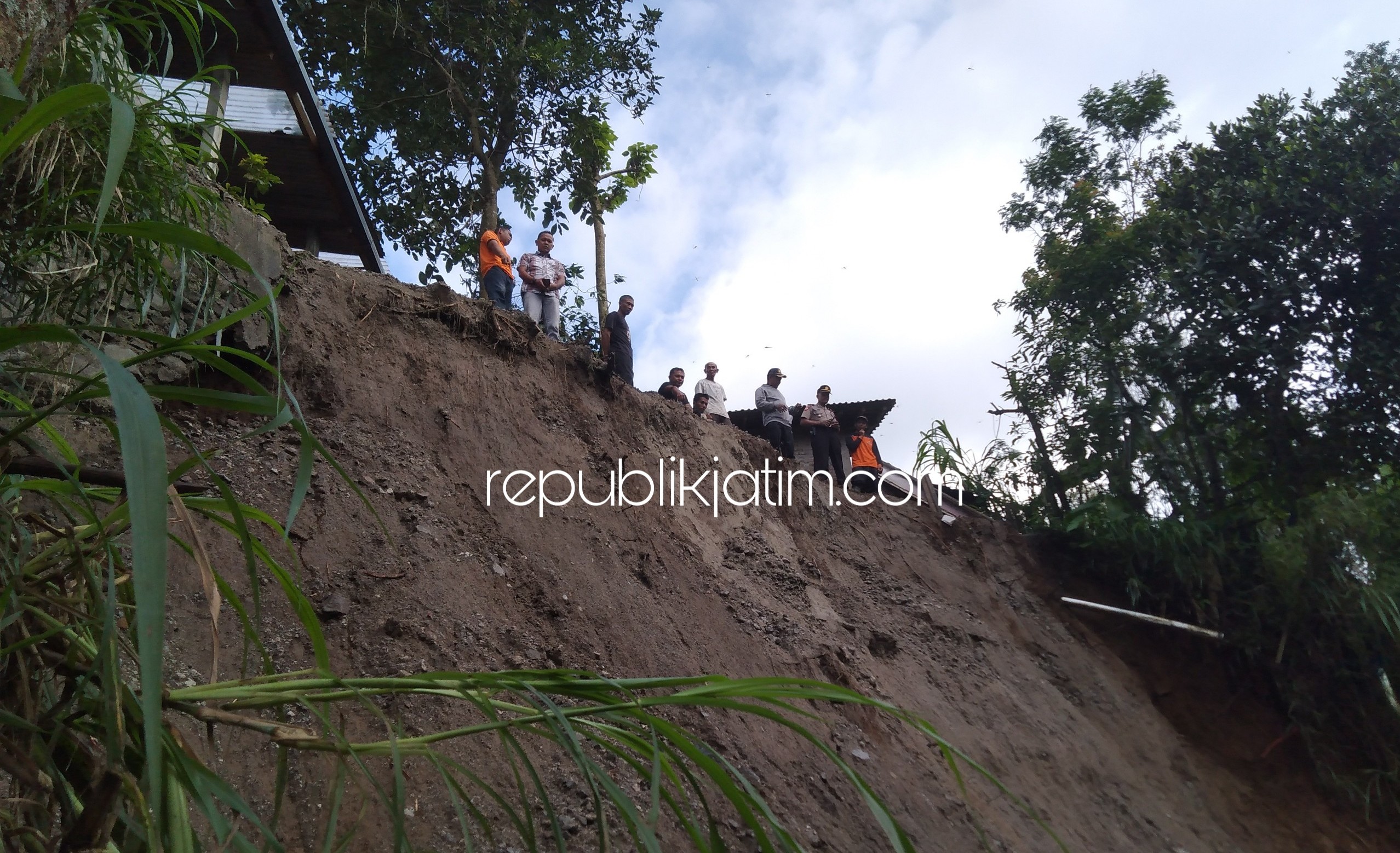 LONGSOR - Kapolsek Pudak Iptu Joko Santoso bersama perangkat Desa Pudak mengecek lokasi Plengseng Ambrol karena hujan deras, Jumat (28/02/2020).