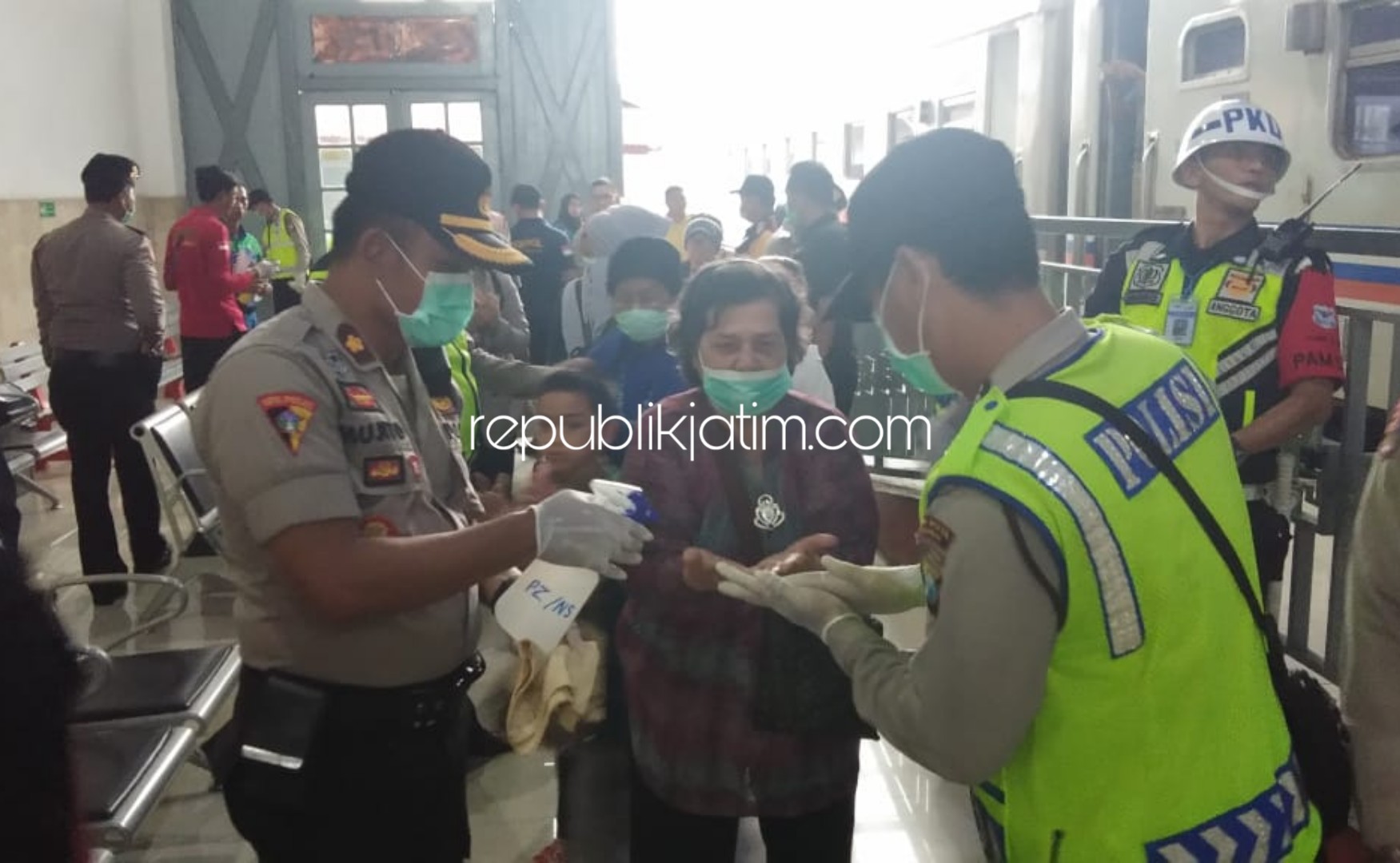 PENCEGAHAN - Petugas gabungan Polresta Sidoarjo, TNI, Dinas Kesehatan dan KAI menyemprotkan cairan disinfektan ke tangan para pengunjung di stasiun Kereta Api (KA) Sidoarjo sebagai upaya pencegahan virus Corona, Sabtu (14/03/2020).