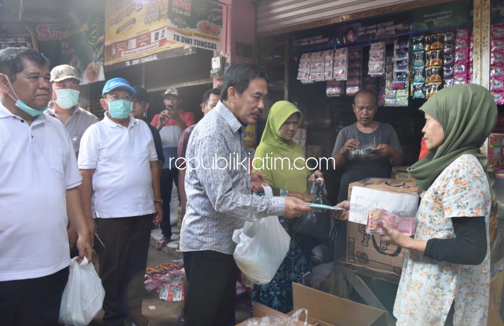 MASKER - Wabup Sidoarjo, Nur Ahmad Syaifuddin dan Kepala Dinkes drg Syaf Satriawarman membagikan masker ke para pedagang dan pengunjung pasar Larangan, Kecamatan Candi, Sidoarjo, Minggu (22/03/2020).