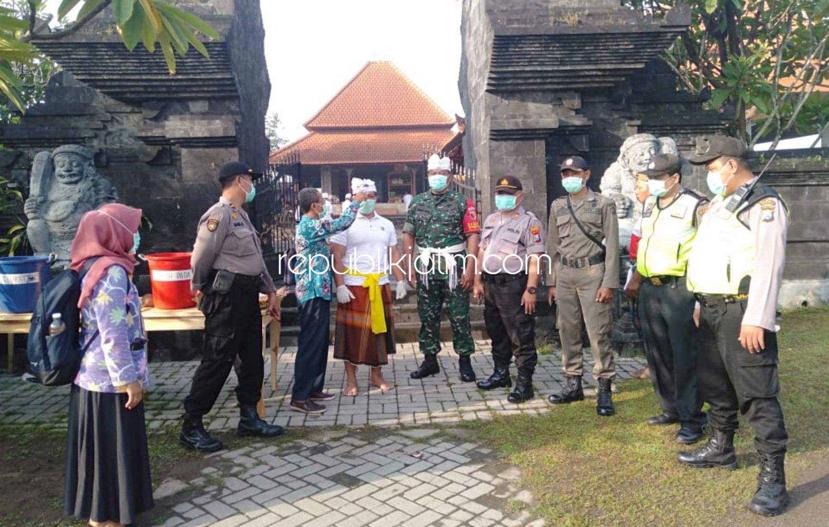 PERIKSA - Petugas Puskesmas Krembung mengecek umat Hinda yang bakal melaksanakan Nyepi di Pura Margo Wening, Desa Balonggarut, Krembung, Sidoarjo, Selasa (24/03/2020) petang.