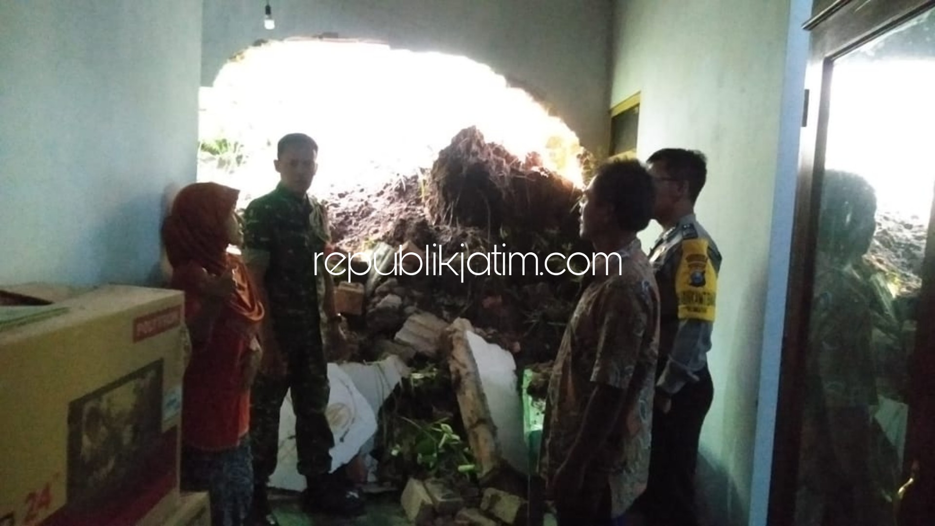 EVAKUASI - Tim gabungan bersama warga bahu-membahu membersihkan material longsor yang menjebolkaan rumah Parni warga Dusun Krajan, Desa Mrayan, Kecamatan Ngrayun, Ponorogo, Rabu (25/03/2020).