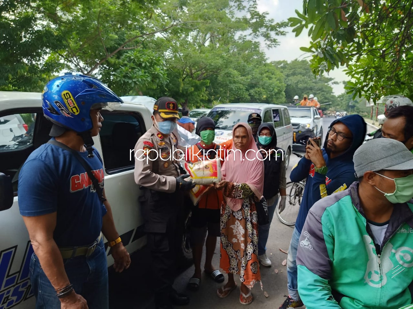 BAKSOS - Kapolsek Kota, Kompol Supiyan membagikan sembako sambil menyemprotkan disinfektan di wilayah Sidoarjo Kota bersama sejumlah komunitas, Sabtu (04/04/2020).