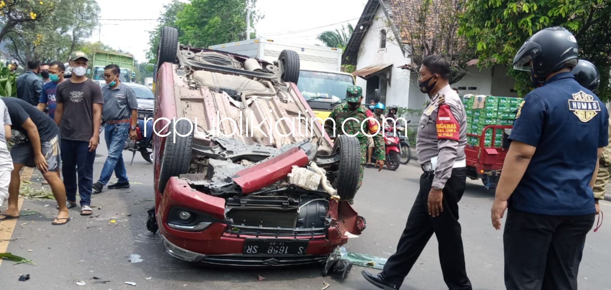 TERBALIK - Kondisi mobil Suzuki Ertiga yang terbalik di tengah jalan ringsek bagian depan setelah menabrak tanaman dan pohon di depan Stasiun KA Tanggulangin, Sidoarjo, Selasa (06/04/2021).