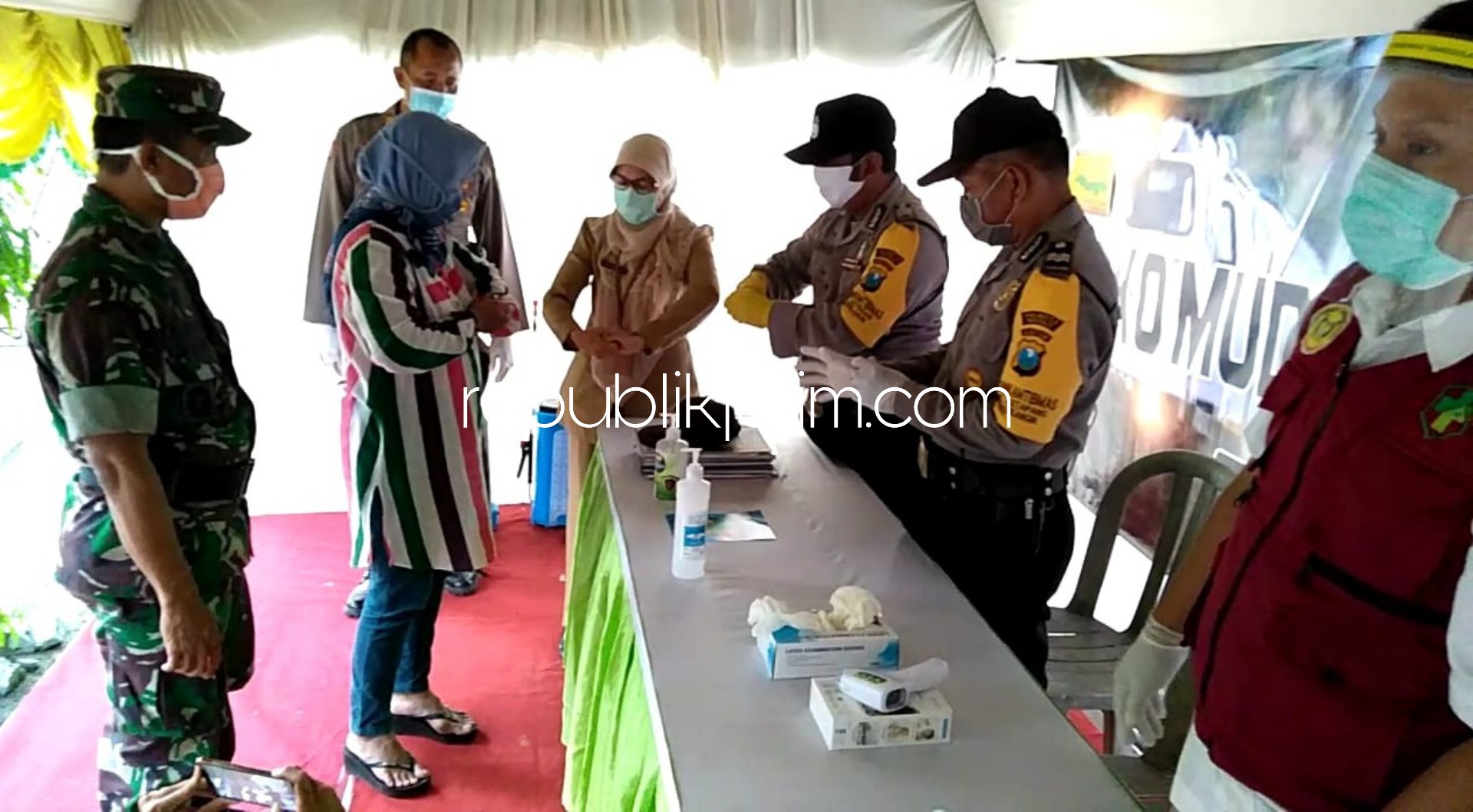 PANTAU - Wakapolsek Tanggulangin, AKP Slamet Agus Sumbono (kanan) memantau di Posko Mudik dan Pelayanan Covid-19 di Station Kereta Api (KA) Tanggulangin, Sidoarjo, Senin (06/04/2020).