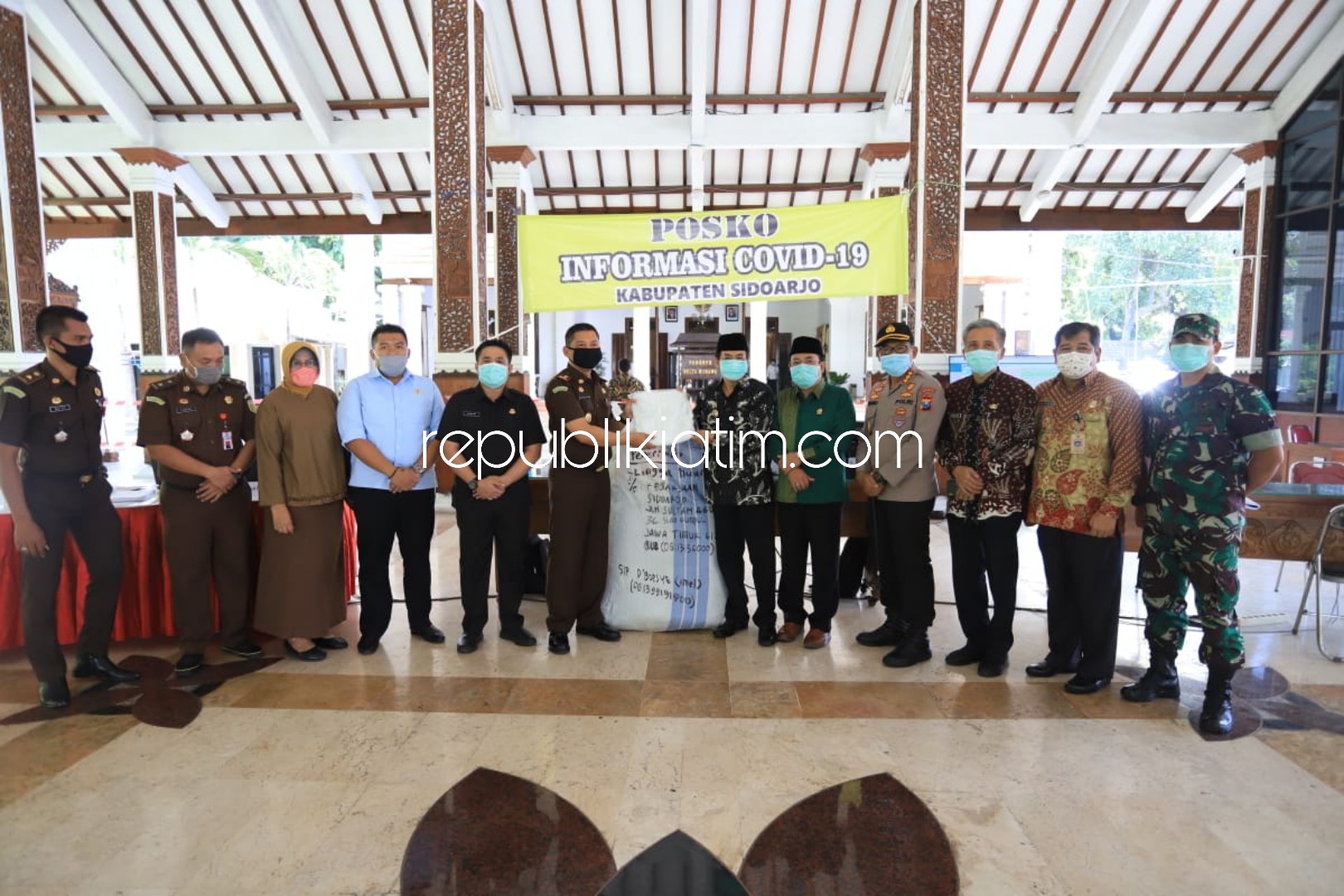 SERAHKAN - Kepala Kejari Sidoarjo, Setiawan Budi Cahyono menyerahkan bantuan Alat Pelindung Diri (APD) ke Ketua Gugus Tugas Covid-19 Sidoarjo, Nur Ahmad Syaifuddin di Pendopo Delta Wibawa, Selasa (07/04/2020).