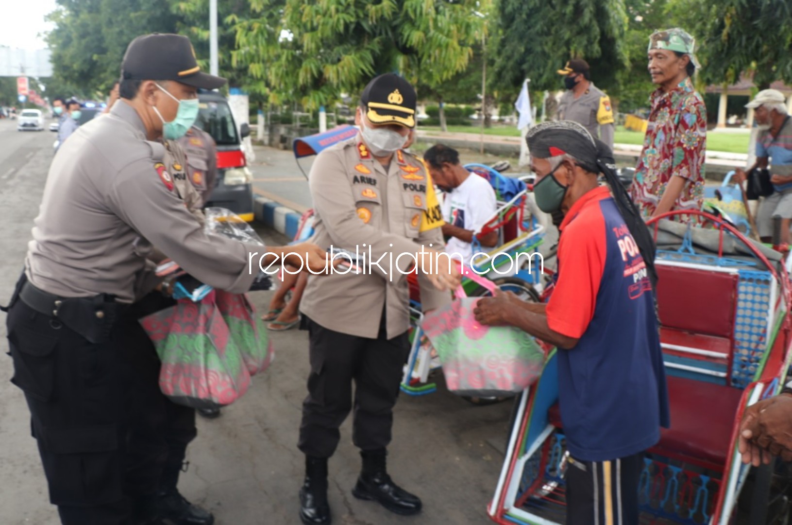 BAGI SEMBAKO - Kapolres Ponorogo AKBP Arief Fitrianto bersama rombongan membagikan sembako dan masker ke para penarik becak di Ponorogo, Selasa (07/04/2020).