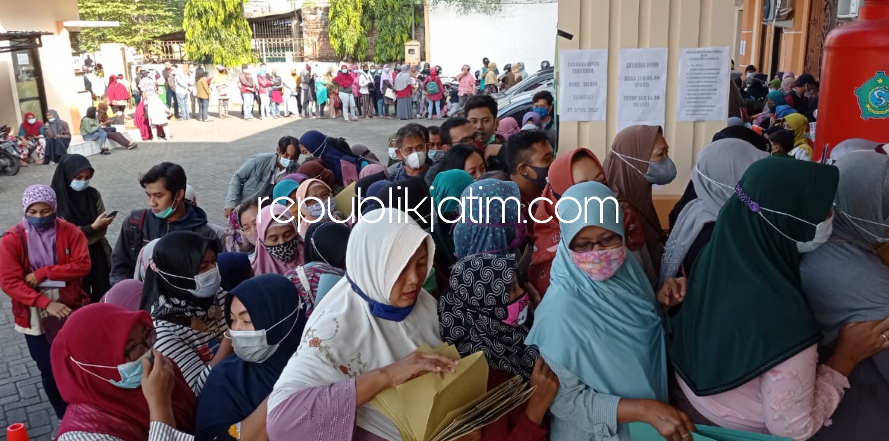 ANTRE - Ratusan calon penerima bantuan UMKM senilai Rp 1,2 juta antre panjang di depan Kantor Dinas Koperasi dan Usaha Mikro Pemkab Sidoarjo hingga di JL Raya Jaksa Agung Suprapto, Sidoarjo, Jumat (23/05/2021).