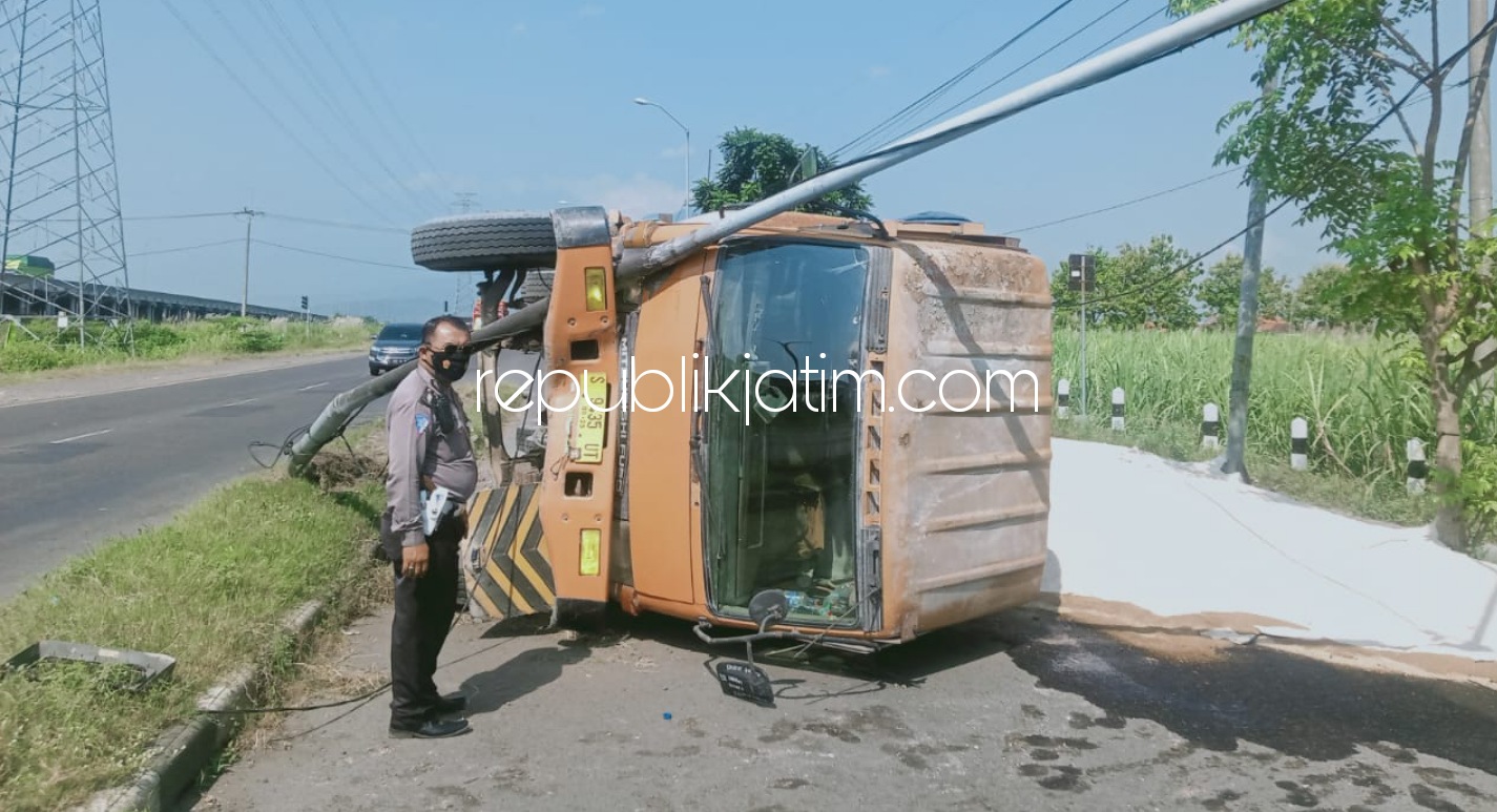 TERGULING - Sebuah dump truk bernopol S 9435 UT yang dikemudikan Imam Sunardi (55) warga JL Raya Undaan, Kecamatan Turen, Kabupaten Malang terguling di Jalur Arteri Porong, Desa Pamotan, Kecamatan Porong, Sidoarjo, Sabtu (01/05/2021).