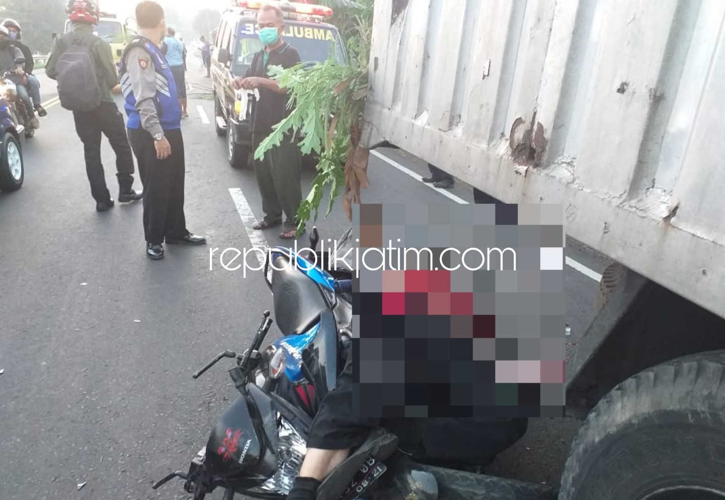 EVAKUASI - Petugas Unit Lantas Polsek Balongbendo mengevakuasi dan menggelar olah TKP kecelakaan di JL Raya Surabaya - Mojokerto seusai motor korban menabrak truk bok yang parkir di pinggir jalan antar propinsi ini, Sabtu (16/05/2020).