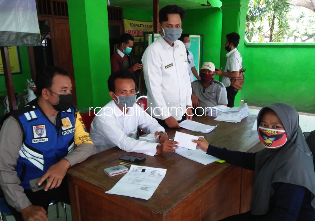 CAIR - Petugas menyerahkan Bantuan Langsung Tunai (BLT) Dana Desa (DD) kepada 123 penerima di Balai Desa Sumberejo, Kecamatan Wonoayu, Sidoarjo, Rabu (20/05/2020).