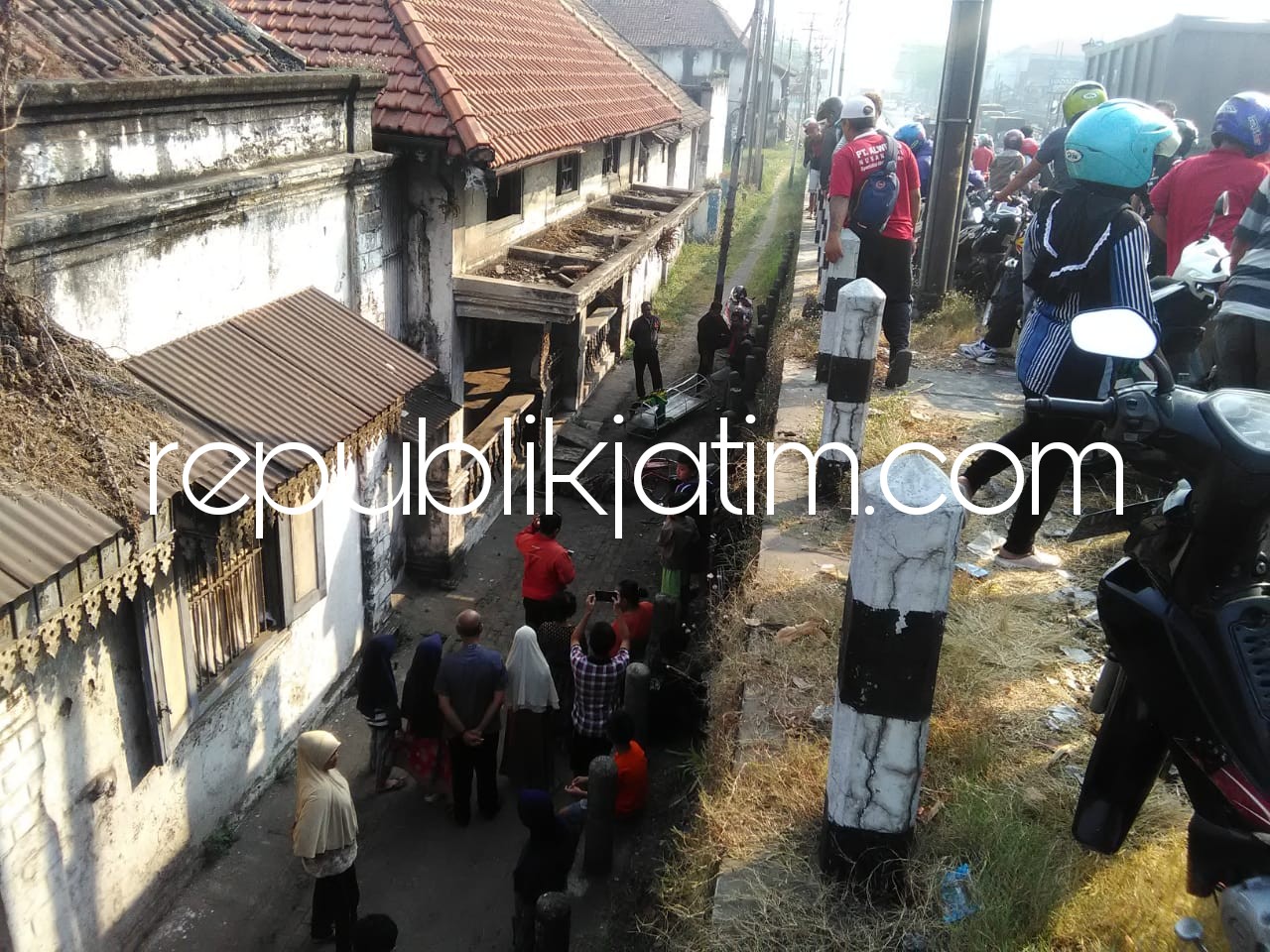 EVAKUASI - Petugas Polsek Porong saat mengevakuasi jenazah korban di Tempat Kejadian Perkara (TKP) menjadi tontonan warga dan pengguna JL Raya Porong, Selasa (29/05/2018).