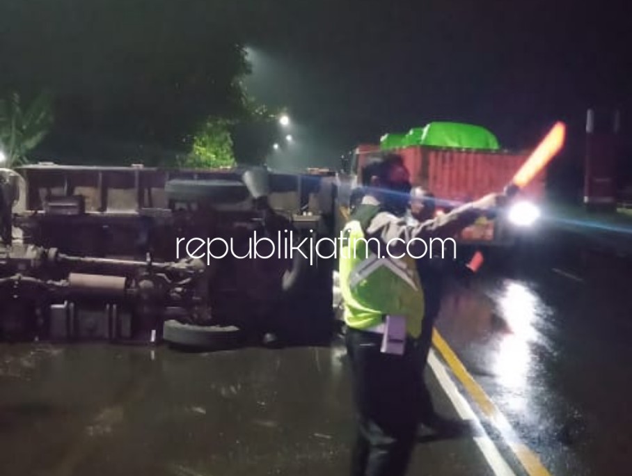 EVAKUASI - Petugas Polsek Balongbendo mengevakuasi truk yang terguling di depan Pos PJR JL Raya Surabaya - Mojokerto, Desa Seduri, Kecamatan Balongbendo, Sidoarjo, Jumat (29/05/2020) dini hari.