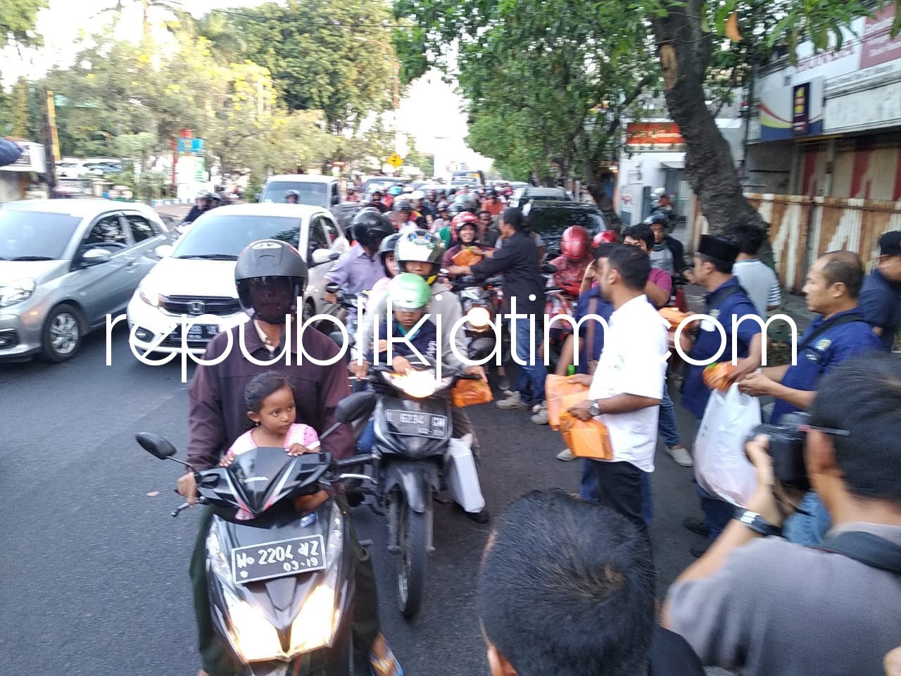 BAGI TAKJIL - Puluhan wartawan Sidoarjo yang tergabung dalam PWI dan Forwas membagikan 300 paket takjil ke para pengguna jalan di depan Balai Wartawan Sidoarjo, Senin (04/06/2018).