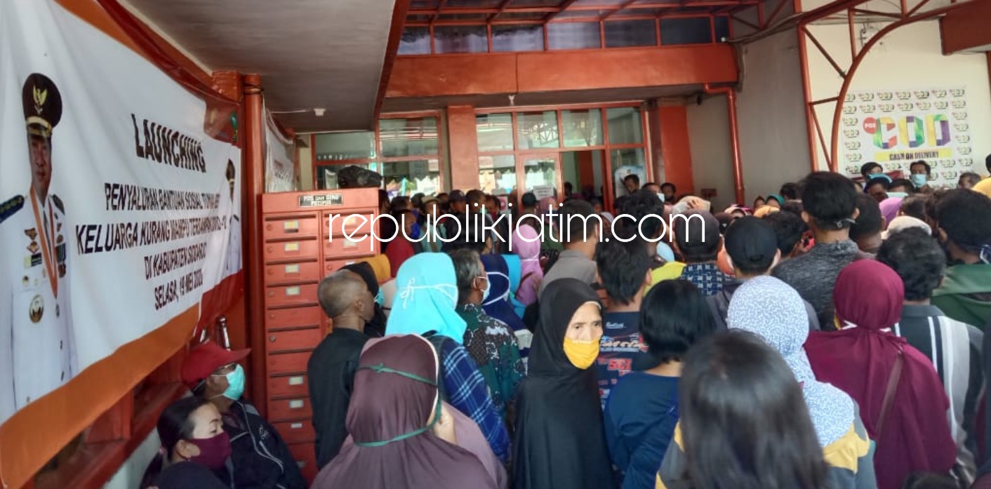 LANGGAR PROTOKOL - Ratusan warga mengantre pencairan Bantuan Sosial Tunai (BST) di Kantor Pos Cabang Sidoarjo tanpa mengindahkan protokol kesehatan karena antreannya tak berjarak sama sekali, Kamis (11/06/2020).