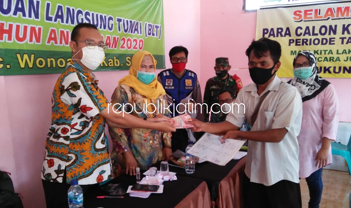 RAPEL - Pj Kepala Desa Popoh, Muslihah (dua dari kiri) beserta Babinsa dan Babinkamtibmas menyaksikan penyerahan rapelan BLT DD tahap 2 dan tahap 3 kepada 99 warganya di Balai Desa setempat, Kamis (18/06/2020).