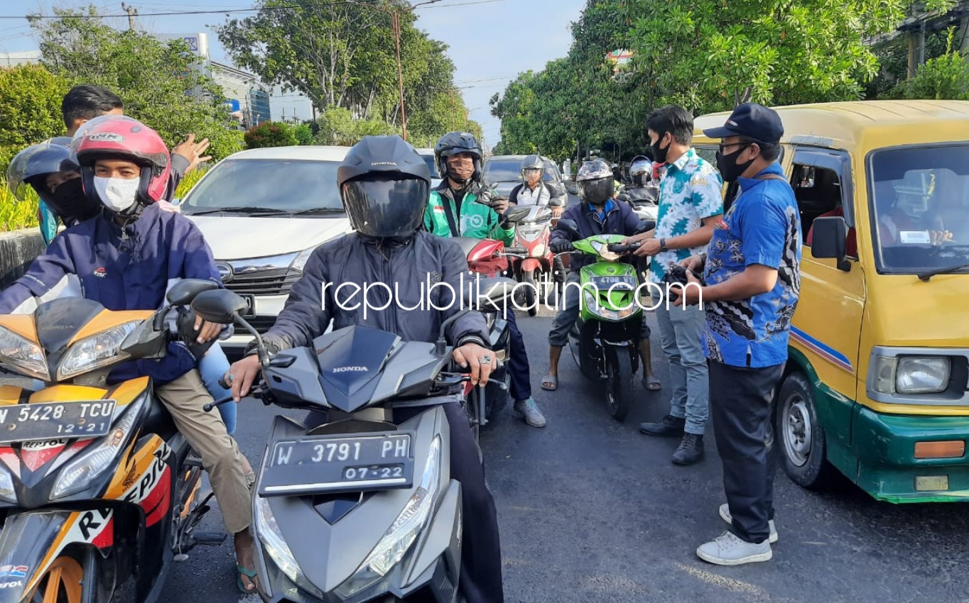 BAGIKAN - Kerjasama dengan BPJS Kesehatan, anggota dan pengurus PWI Sidoarjo membagikan 500 masker dan hand sanitizer kepada para pengguna jalan yang melintas di lampu merah Alun-Alun, Sidoarjo, Senin (22/06/2020) sore.