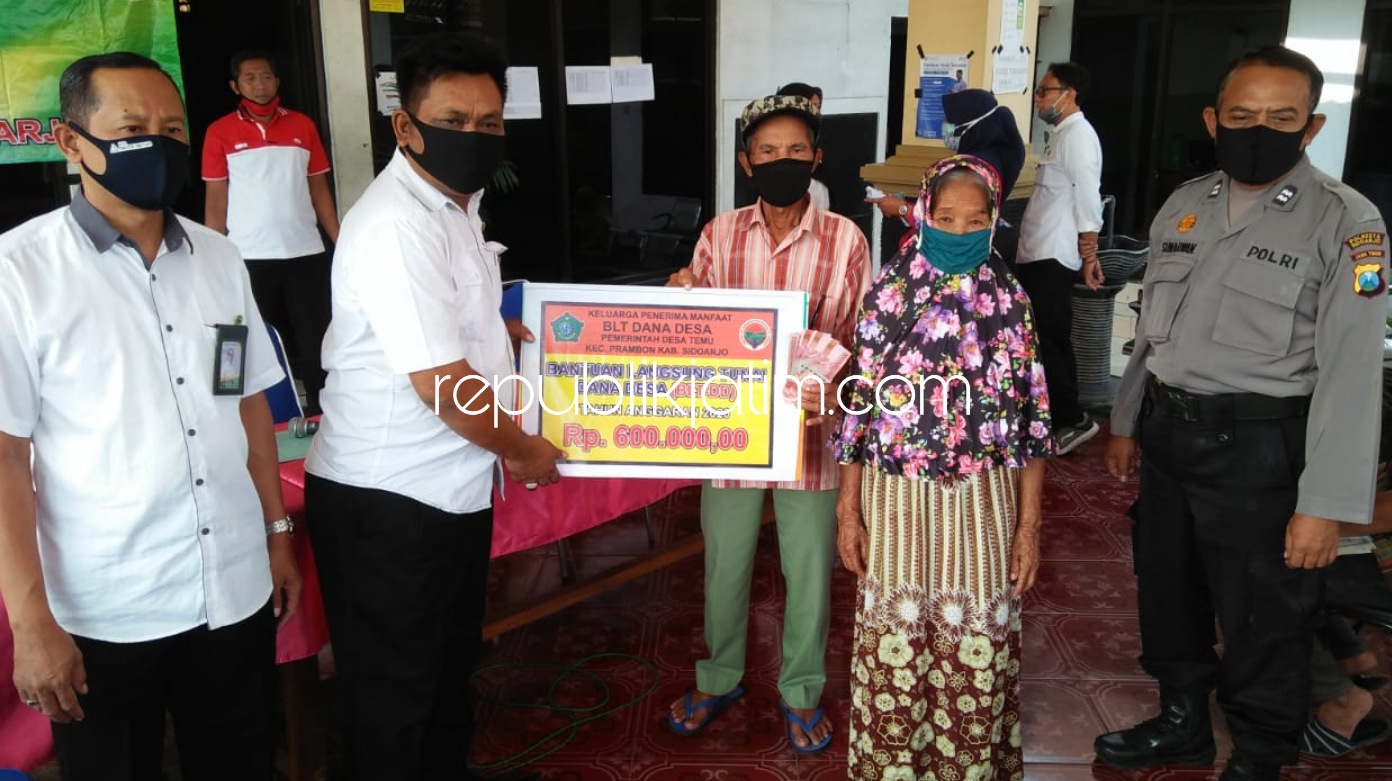 PENYERAHAN - Kades Temu, Kecamatan Prambon, Sidoarjo menyerahkan BLT DD Tahap dua senilai Rp 600.000 untuk 108 warganya di Balai Desa setempat, Rabu (24/06/2020).